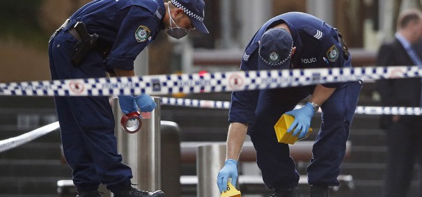 Police officers place marker cones over potential evidence in their investigation into the Sydney cafe siege